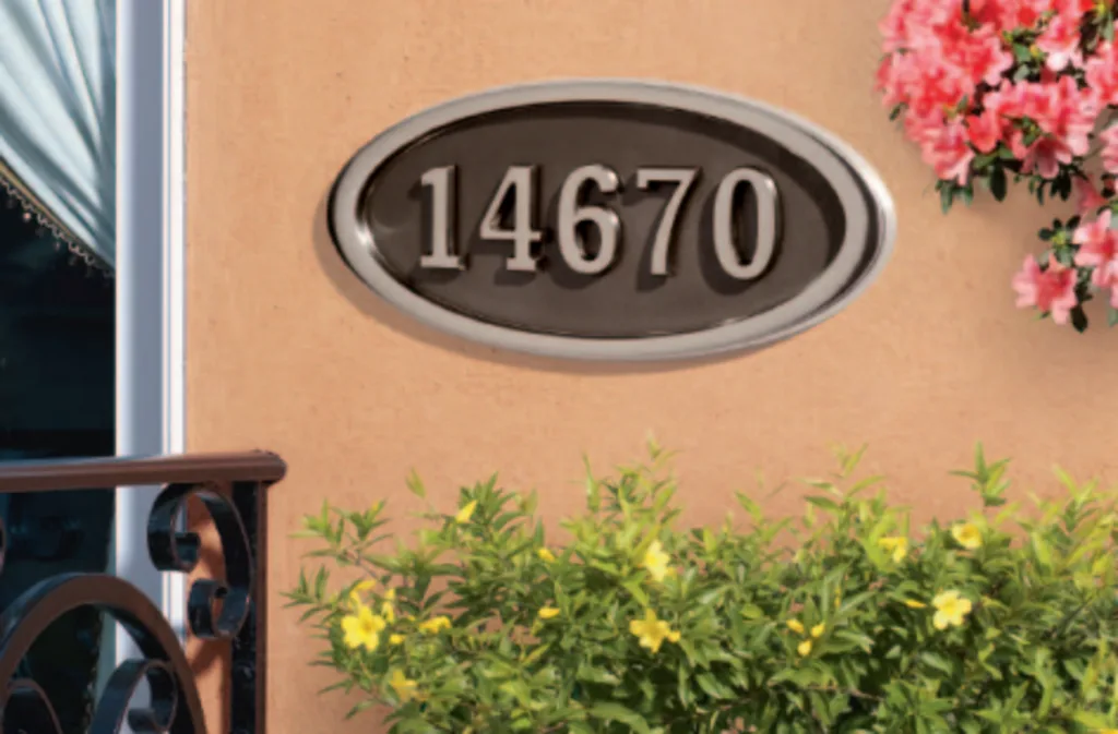 An oval Whitehall house-number plaque mounted beside a door